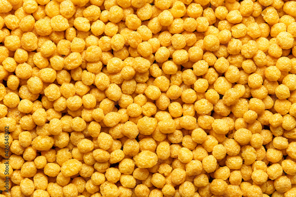 Breakfast cereals with honey, background, top view. Corn cereal balls, close-up Breakfast cereals with honey, background, top view. Corn cereal balls, close-up