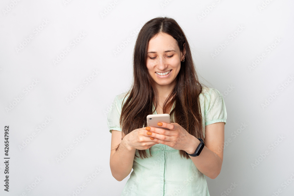 Smiling young happy woman in casual using smart phone over white background Smiling young happy woman in casual using smart phone over white background