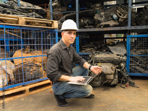 Engineer man working, Caucasian manager using laptop and looking at auto part in factory-warehouse