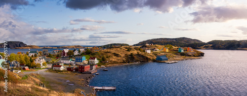 Panoramic view of a small town on the Atlantic Ocean Coast. Dramatic Colorful Sunrise Sky Art Render. Taken in Trinity, Newfoundland and Labrador, Canada.