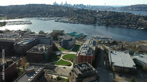 Cinematic aerial drone dolly clip of the University of Washington School of Medicine, Portage Bay by Lake Union, and North Broadway, Montlake, distant cityscape of downtown Seattle, Washington photo