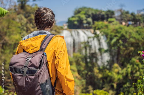 Male tourist on the background of Elephant waterfall near Dalat city in Vietnam