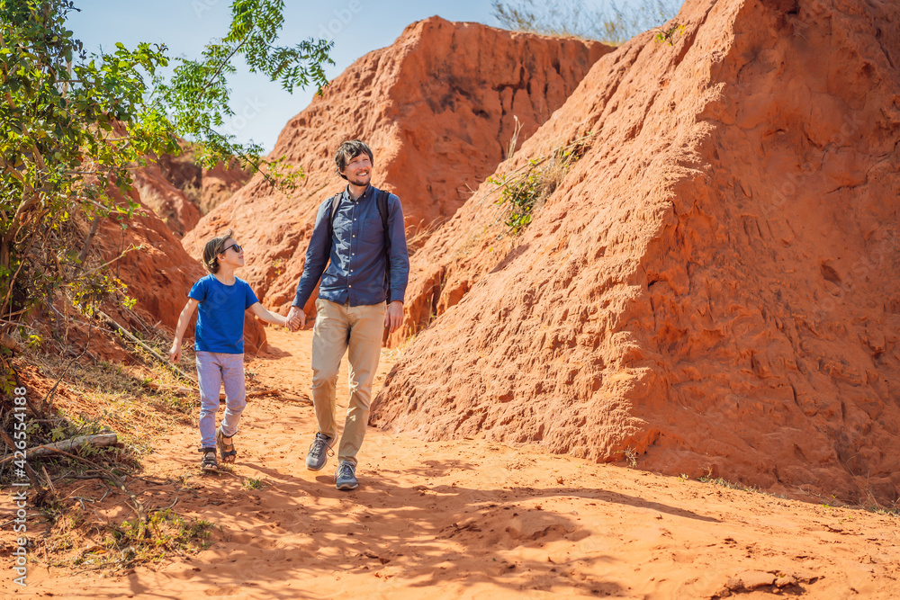 Dad and son tourists in red canyon, resumption of tourism concept. Traveling with children concept Dad and son tourists in red canyon, resumption of tourism concept. Traveling with children concept