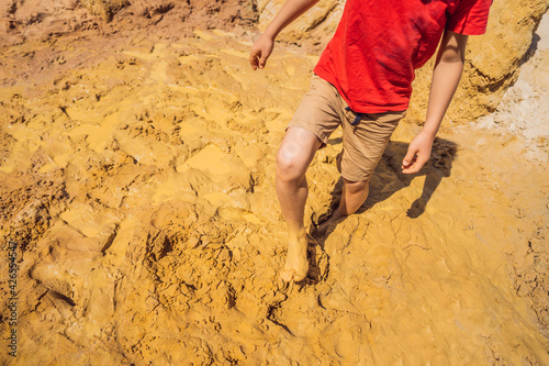 Unlucky person standing in natural quicksand river, clay sediments, sinking, drowning quick sand, stuck in the soil, trapped and stuck concept