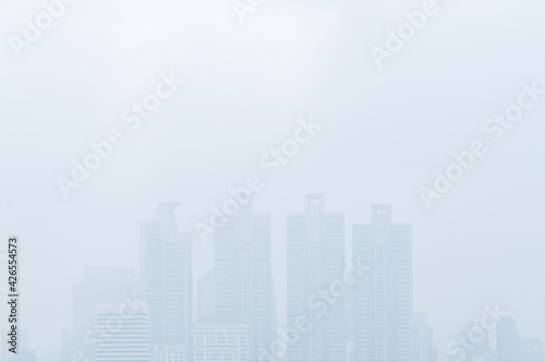 Cityscape in the mist, tall building in thick mist, uncleared or blurred image view, image with blank space area for copy and design. © dul_ny