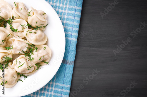 Meat dumplings - Russian dumplings, dumplings with meat on a plate on a black background