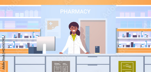 african american female doctor pharmacist standing at pharmacy counter modern drugstore interior medicine healthcare concept horizontal portrait