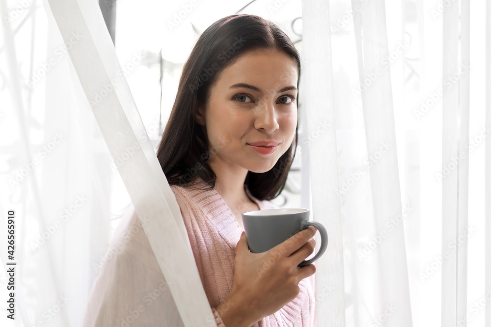 Portrait of smiling happy cheerful beautiful pretty caucasian woman relaxing drinking and looking at cup of hot coffee or tea.Girl felling enjoy having breakfast in holiday morning vacation at home Portrait of smiling happy cheerful beautiful pretty caucasian woman relaxing drinking and looking at cup of hot coffee or tea.Girl felling enjoy having breakfast in holiday morning vacation at home