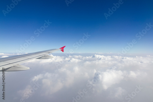 An airplane wing in the sky The sky atmosphere is cloudy and dust is thick. Fly on the Asian continent, Thailand.