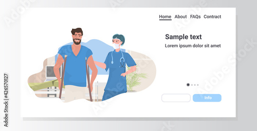 female doctor physical therapist helping male patient on crutches hospital clinic ward healthcare medicine concept portrait horizontal copy space