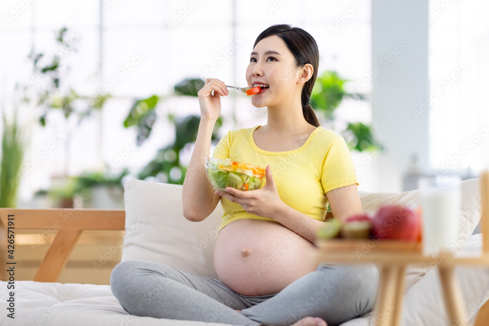 Asian pregnant woman eating salad Asian pregnant woman eating salad