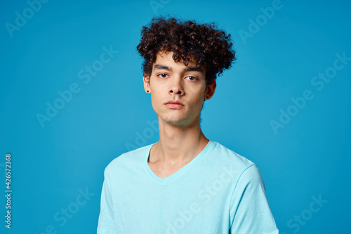 guy with curly hair in blue t-shirt cropped view studio