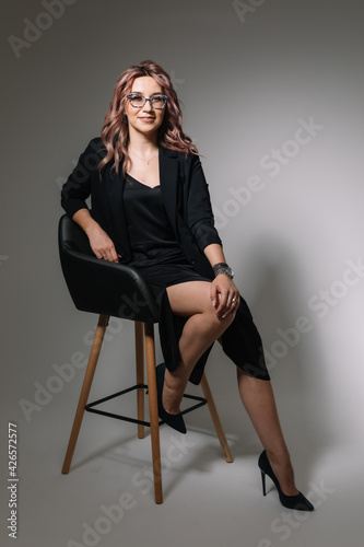 Business woman in glasses in a black dress