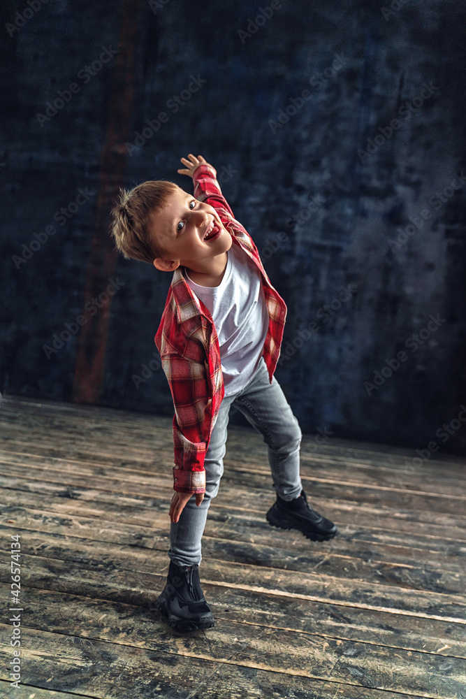 Portrait of a cheerful, smiling, stylishly dressed little boy