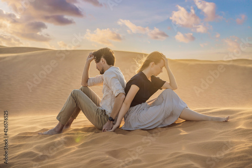Relationship problems between a couple - a man and a woman. Family conflict. Man and woman have a heated relationship, sit in the hot desert with their backs to each other and do not want to talk