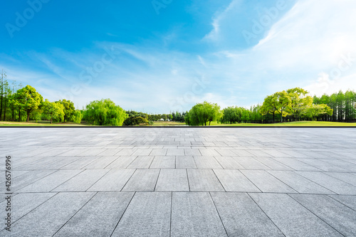 Wide square floor and green trees in natural park. © ABCDstock