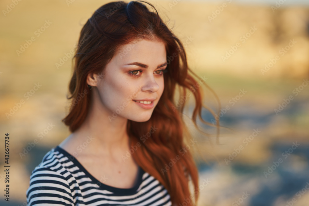 happy woman in striped t-shirt smiling in the mountains outdoors