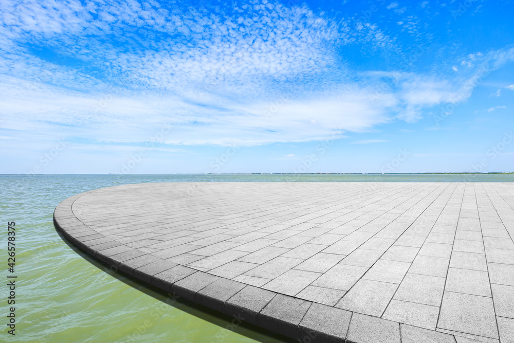 Empty square floor and lake landscape under the blue sky.