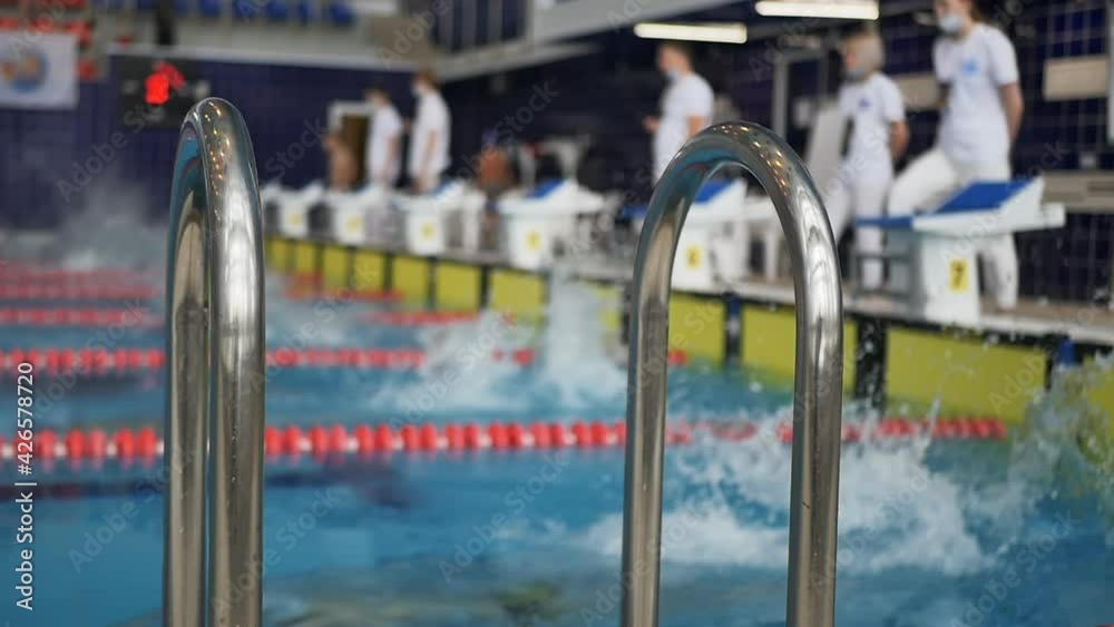 swimmers boys teenagers start jumping into the water. Swimming sports tournament. Slow motion swimmers boys teenagers start jumping into the water. Swimming sports tournament. Slow motion