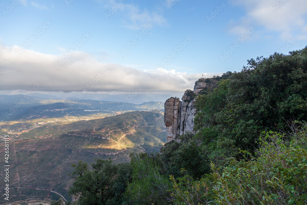 Breathtaking view of the Montserrat mountain range on a sunny spring day near Barcelona, Catalonia, Spain. Colorful mountain landscape. The shadow of the clouds falls to the ground.