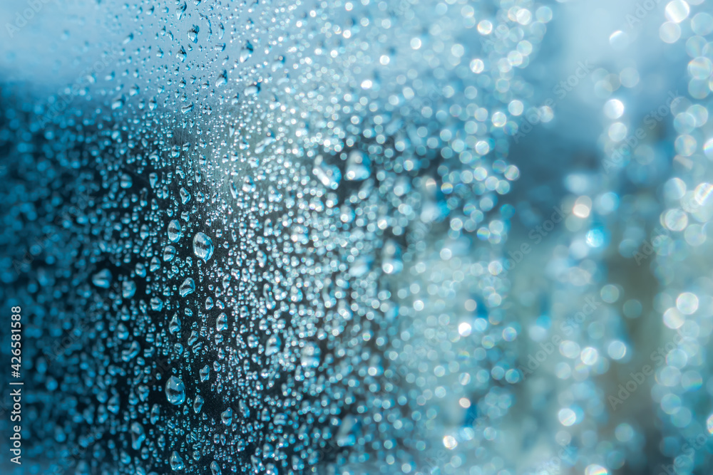 Abstract blue background with raindrops and beautiful bokeh. The concept of autumn and the cold stormy weather. Texture of macro drops on the blurred background of the window. Loneliness sadness Abstract blue background with raindrops and beautiful bokeh. The concept of autumn and the cold stormy weather. Texture of macro drops on the blurred background of the window. Loneliness sadness