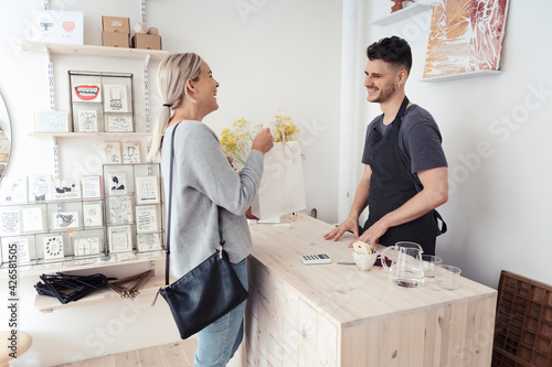 Happy female customer talking with male owner at design studio photo