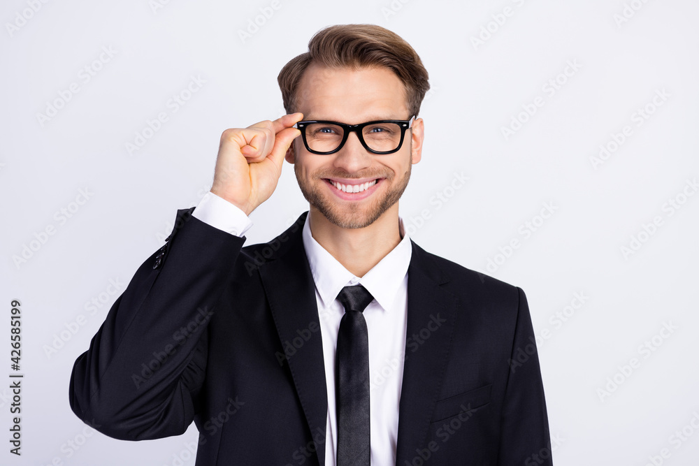 Photo of young handsome business man happy positive smile hand touch glasses isolated over grey color background