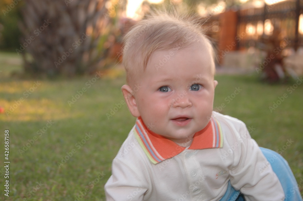 boy sitting in the grass cute baby small face portrait boy sitting in the grass cute baby small face portrait