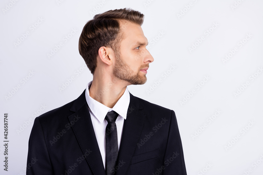 Profile side photo of young business man concentrated focused look empty space isolated over grey color background Profile side photo of young business man concentrated focused look empty space isolated over grey color background
