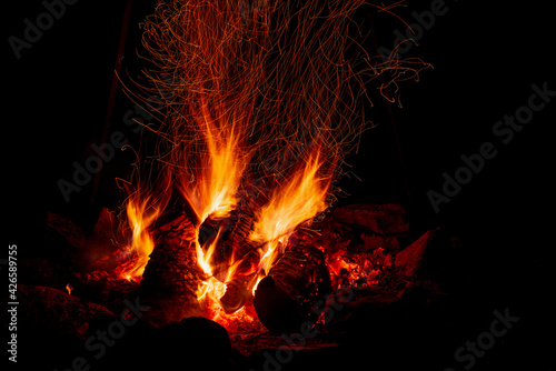 Night campfire with available space. Big bonfire against black background. Sparks of bonfire and fire close up