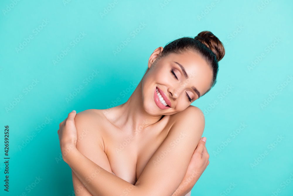 Obraz premium Portrait of attractive dreamy cheerful trendy girl hugging herself freshness isolated over bright teal turquoise color background