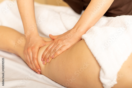 Closeup photo of the anticellulite massage by a physiotherapist. Young girl is relaxing in the spa. Foot massage.