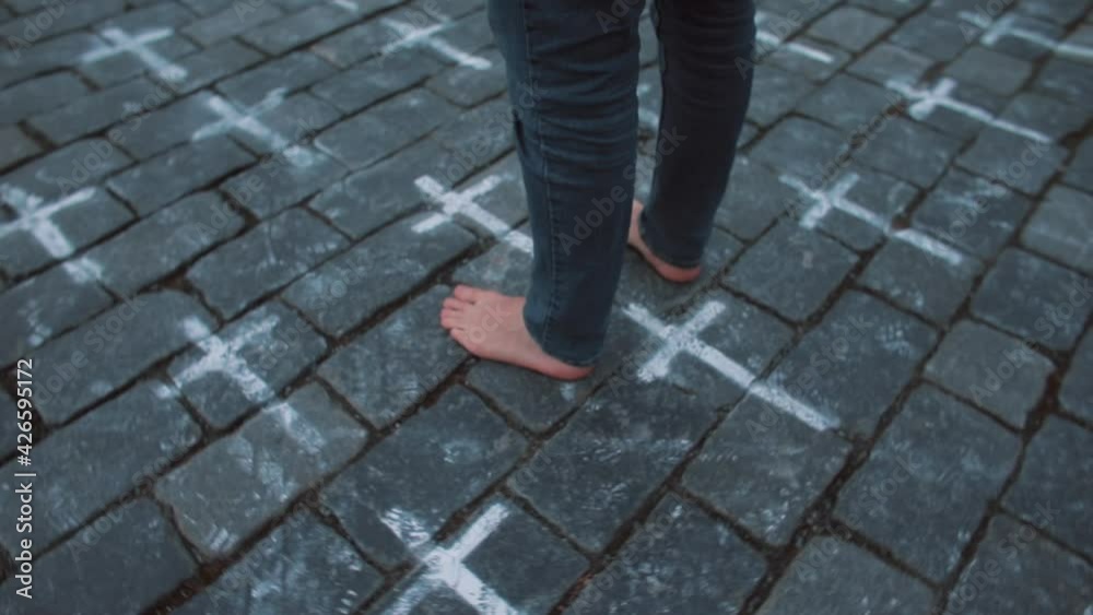 Pilgrim's bare feet on stone floor. Crosses drawn. Symbolising the right path. A place of purification, an invisible connection. Circular movement of the camera. Pilgrim's bare feet on stone floor. Crosses drawn. Symbolising the right path. A place of purification, an invisible connection. Circular movement of the camera.