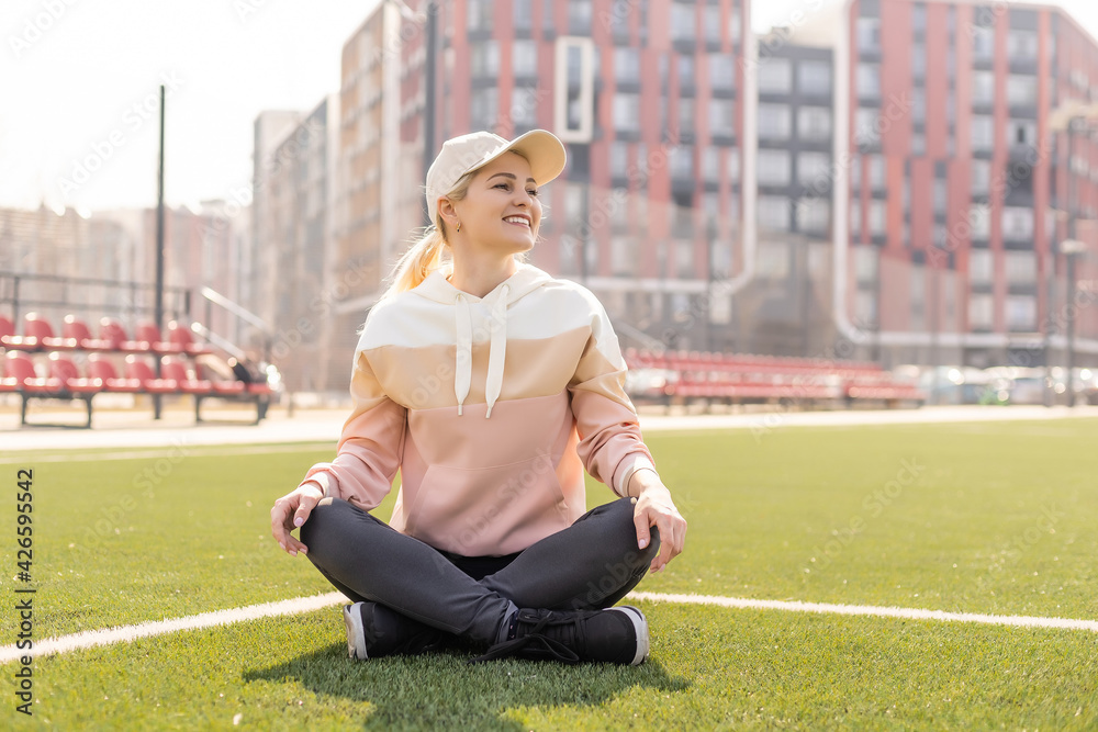 Fototapeta premium Sport. Fitness Girl Doing Stretching Workout. Fashion Sporty Woman With Strong Muscular Body Training. Fit Female Stretching At Outdoor Stadium.