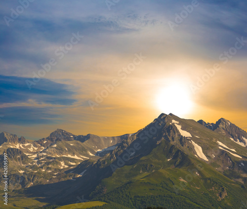 mountain chain in a snow at the dramatic sunset, natural travel background