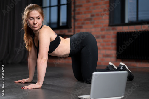 Online Training. Fit Young Woman Excersising At Home, Watching Video Tutorial On Laptop. Red head woman.