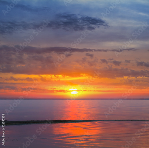 dramatic sunset over the quiet sea bay