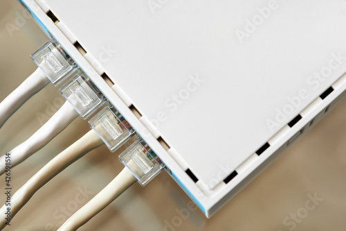 Ethernet cables connected to Desktop Switch or routerboard. Close-up, selective focus photo