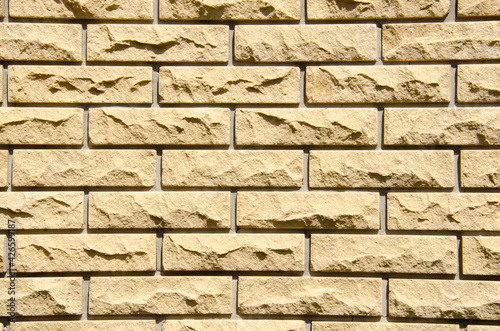 Close-up beige brick wall with copy space. Grunge brick wall background. Beige brick wall for texture. Decorative brick wall surface.