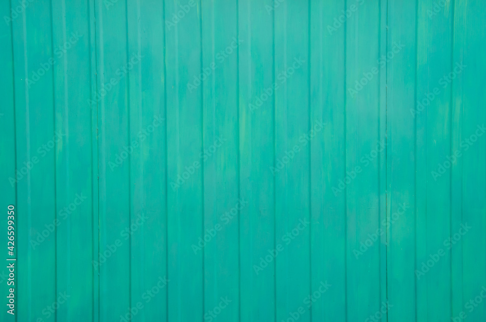 Green metal tile fence background. Fence from corrugated board. Emerald slate background. Zinc metal sheet texture. Steel panel of the enclosing wall. Green metal tile fence background. Fence from corrugated board. Emerald slate background. Zinc metal sheet texture. Steel panel of the enclosing wall.