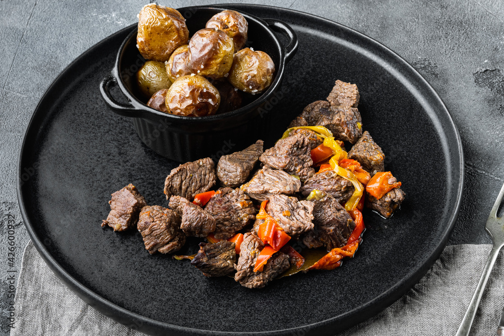 Beef bourguignon stew with vegetables, on gray stone background