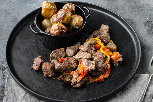 Beef bourguignon stew with vegetables, on gray stone background