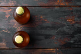 Glass bottles of beer, on old dark  wooden table , top view flat lay, with copy space for text