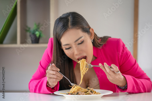 Hungry people eating spaghetti. A plate of pasta and a fork wildly eats pasta.