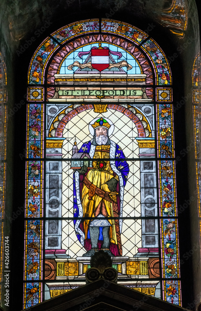 Budapest, Hungary - July 14 2019: antique skilful stained glass window on an arched window in the St. Stephen's Basilica in Budapest, Hungary. Ancient traditional interior of a catholic temple