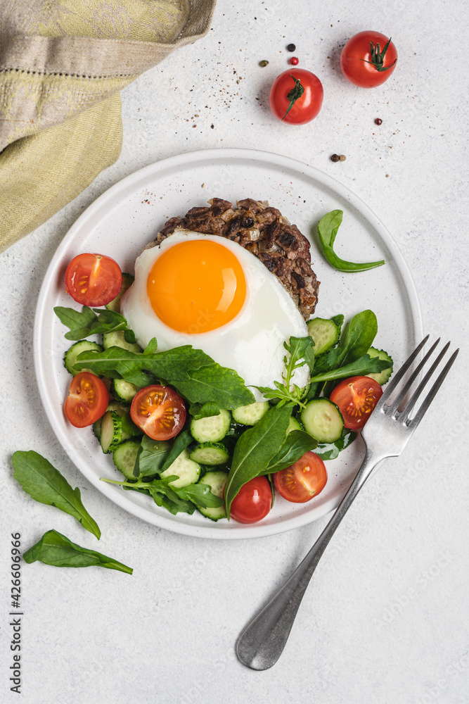 Chopped beef steak with fried egg and salad. Delicacy dinner in plate on white background. Healthy food concept Chopped beef steak with fried egg and salad. Delicacy dinner in plate on white background. Healthy food concept