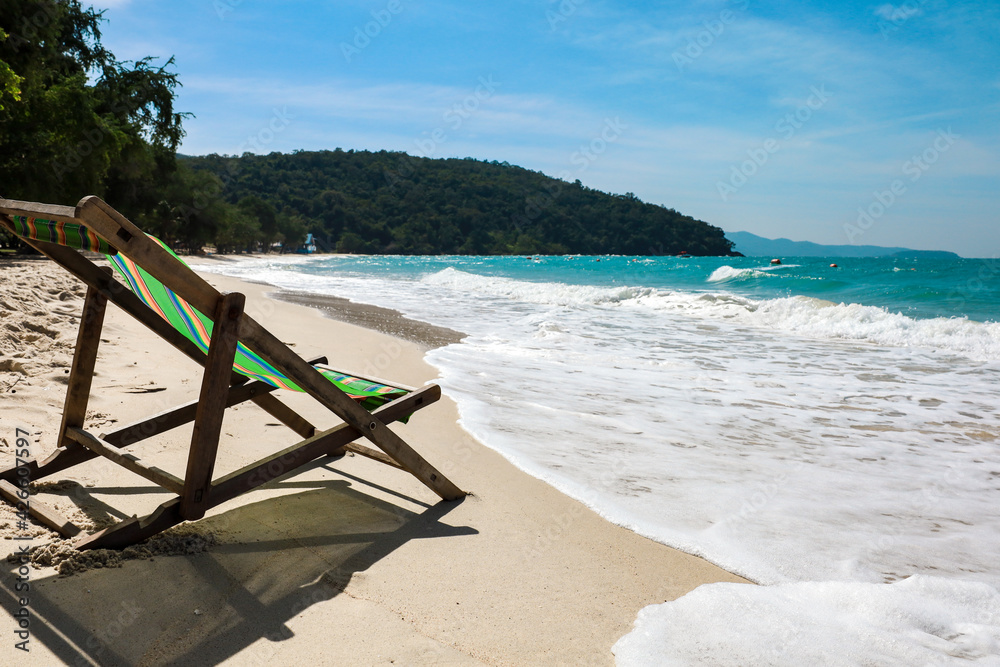 Green Deck chair at the tropical sandy beach with blue wave and clear sky in summer time Green Deck chair at the tropical sandy beach with blue wave and clear sky in summer time