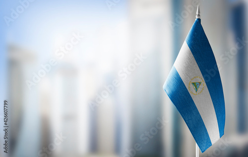 A small flag of Nicaragua on the background of a blurred background