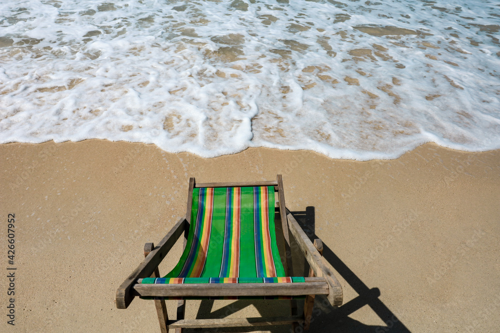 Green Deck chair at the tropical sandy beach with blue wave and clear sky in summer time Green Deck chair at the tropical sandy beach with blue wave and clear sky in summer time