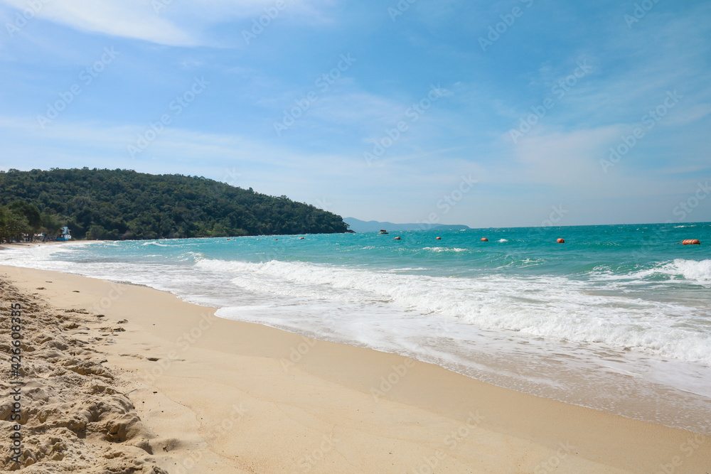 the tropical sandy beach with blue wave and clear sky in summer time